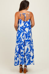 woman wearing a blue and white floral maternity maxi dress with a tie back and flowy skirt