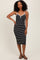 woman wearing a black and white striped midi dress with spaghetti straps and a v-neckline