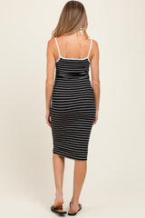 woman wearing a black and white striped maternity midi dress with spaghetti straps, showing her back