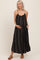 woman wearing a black and white striped maternity maxi dress with a flowing silhouette and pockets, highlighting her baby bump