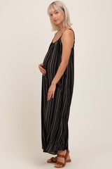 woman wearing a black maternity maxi dress with white stripes and holding her baby bump