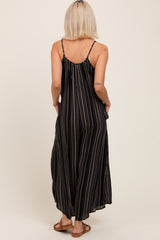 woman wearing a black and white striped maternity maxi dress with adjustable spaghetti straps and pockets, showing a relaxed fit