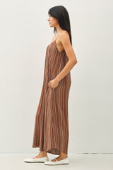 woman wearing a brown maxi dress with white vertical stripes and adjustable straps