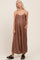 woman wearing a brown striped maternity maxi dress with adjustable straps and pockets, showing her baby bump
