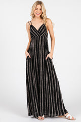 woman wearing a black and white striped maxi dress with pockets and thin adjustable straps