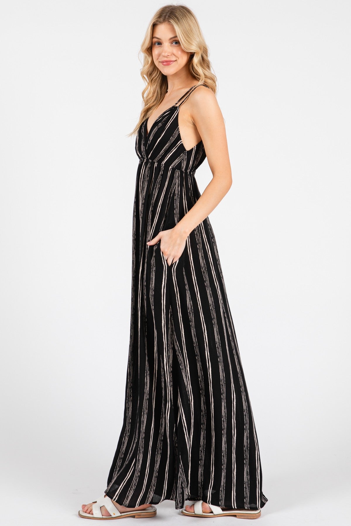 woman wearing a black and white striped maxi dress with thin straps and pockets