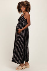 woman wearing a black and white striped maternity maxi dress and holding her baby bump