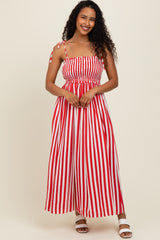 woman wearing a red and white striped maxi dress with adjustable tie straps and a smocked bodice
