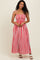 woman wearing a red and white striped maxi dress with adjustable tie straps and a smocked bodice