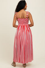 woman wearing a red and white striped maxi dress with smocked bodice and tied straps, shown from the back