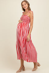 woman wearing a red and white striped maternity dress with tie straps and a visible baby bump