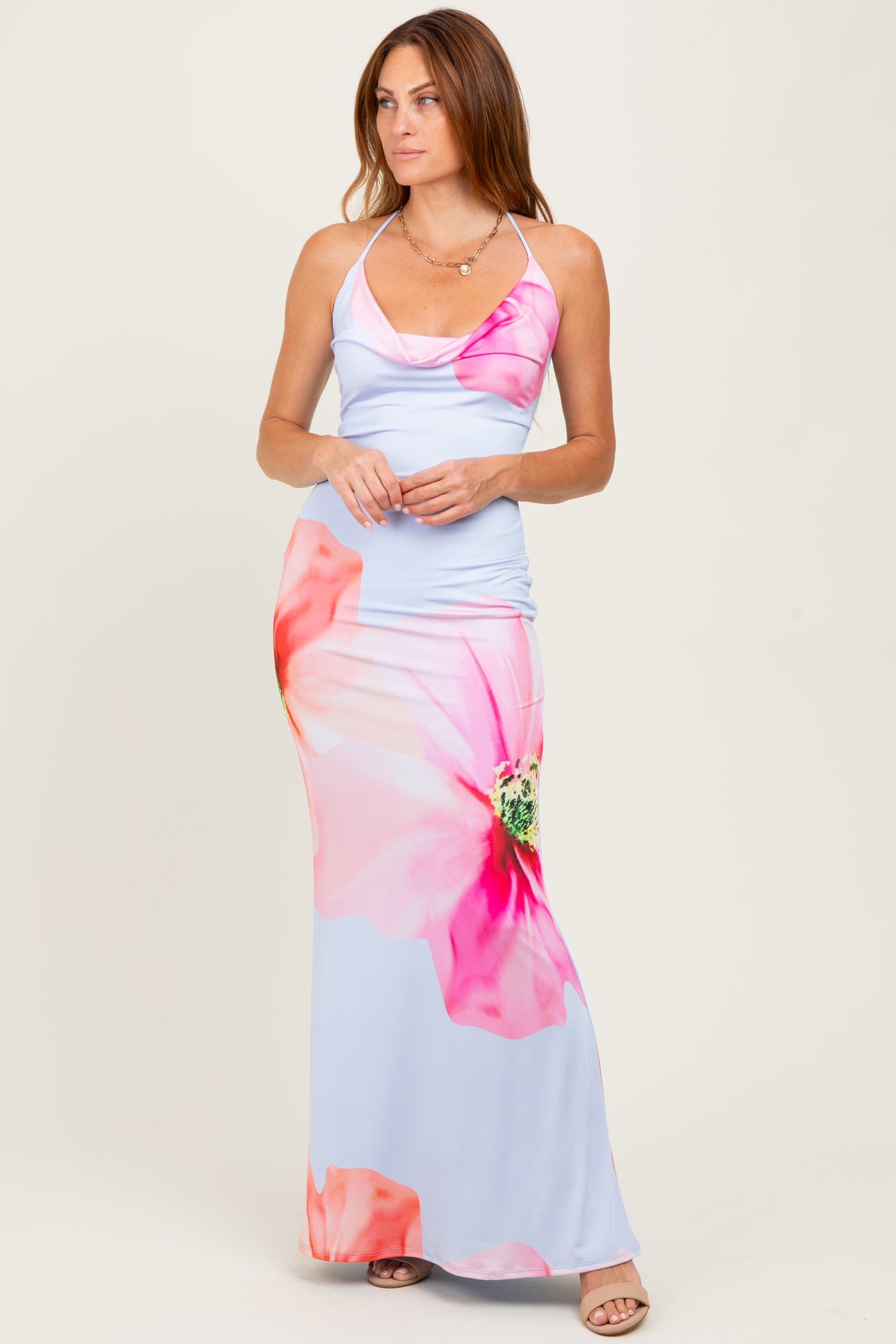 woman wearing a light blue maxi dress with pink floral prints and spaghetti straps