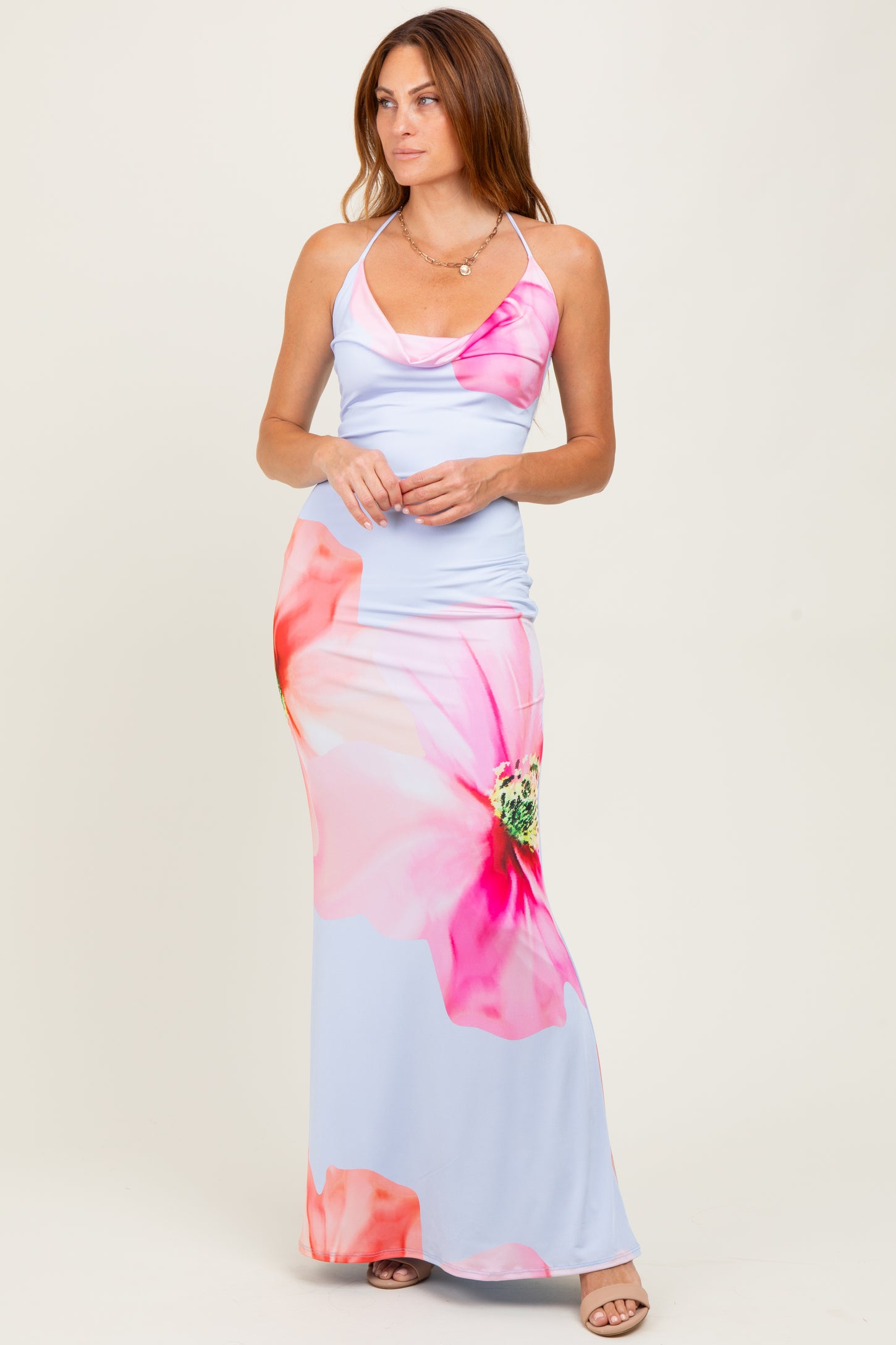 woman wearing a light blue maxi dress with pink floral prints and spaghetti straps