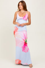 woman wearing a light blue maxi dress with pink floral prints and spaghetti straps