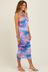 woman wearing a pastel floral print halter neck midi dress with ruched detailing