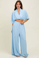 woman wearing a light blue two-piece set with a cropped top and wide-leg pants