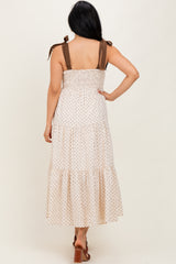 woman wearing a polka dot midi dress with brown tie straps and smocked bodice, shown from the back