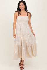 woman wearing a cream and brown polka dot maxi dress with smocked bodice and adjustable straps