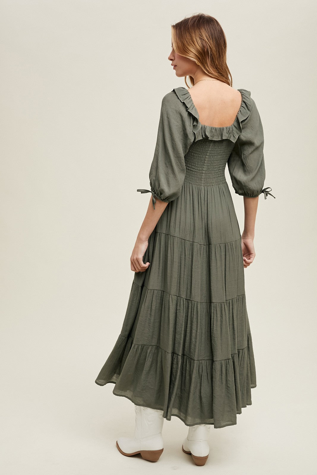 woman wearing an olive green tiered maxi dress with puff sleeves and a smocked back detail