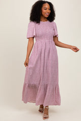 woman wearing a floral print pink maxi dress with short sleeves and tiered detailing