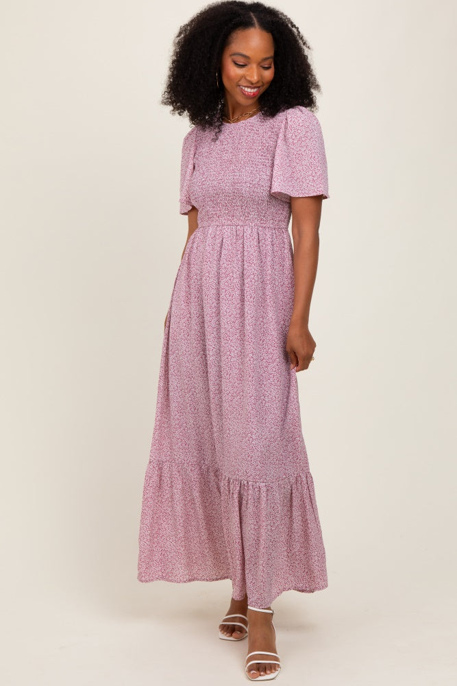 woman wearing a pink floral maxi dress with short puff sleeves and a tiered skirt