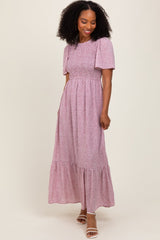 woman wearing a pink floral maxi dress with short puff sleeves and a tiered skirt