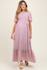 woman wearing a pink floral maternity maxi dress with short puff sleeves and a tiered skirt, baby bump visible