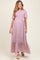 woman wearing a pink floral maternity maxi dress with short puff sleeves and a tiered skirt, baby bump visible