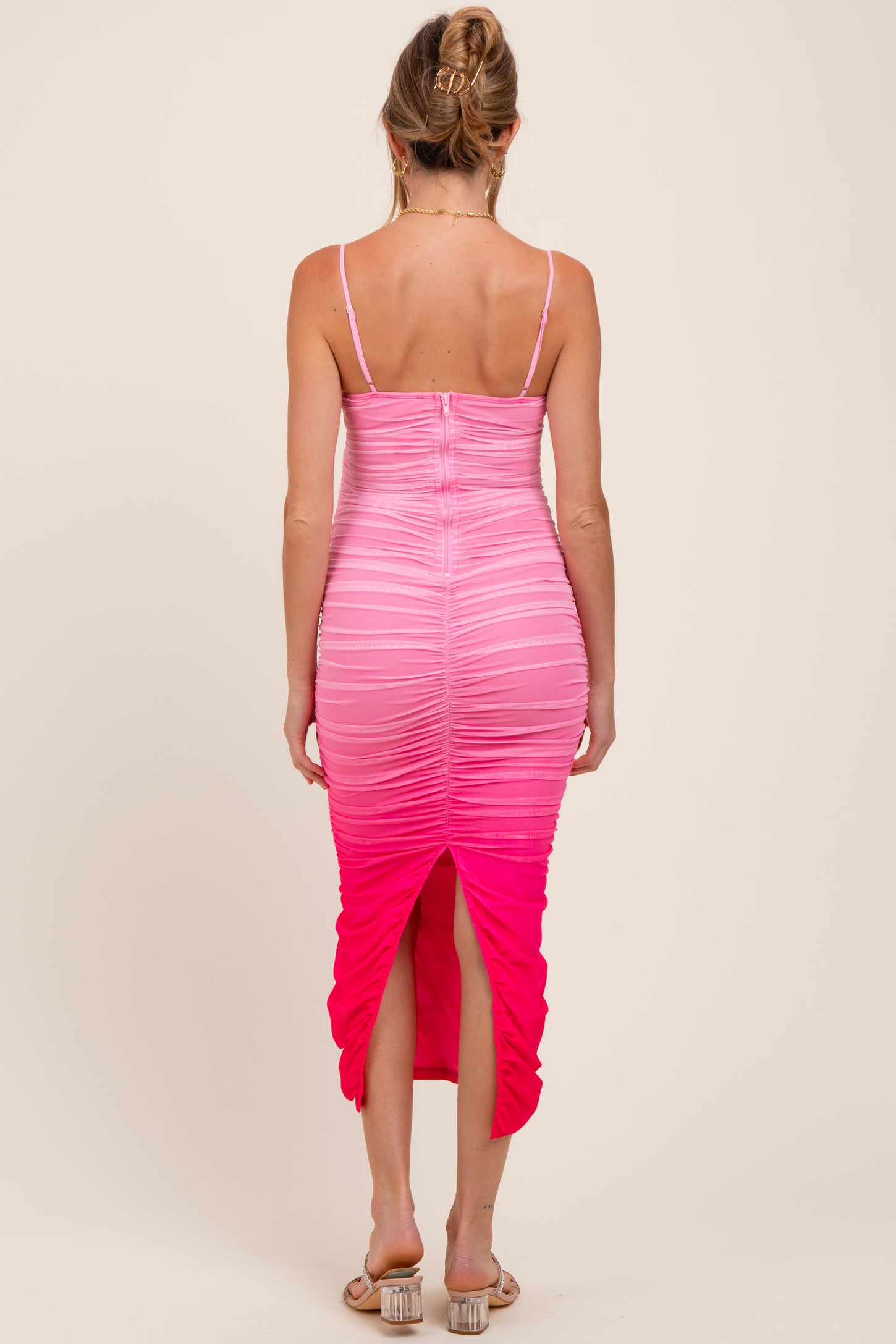 woman wearing a pink ombre maternity dress with spaghetti straps and a back slit, showing a baby bump