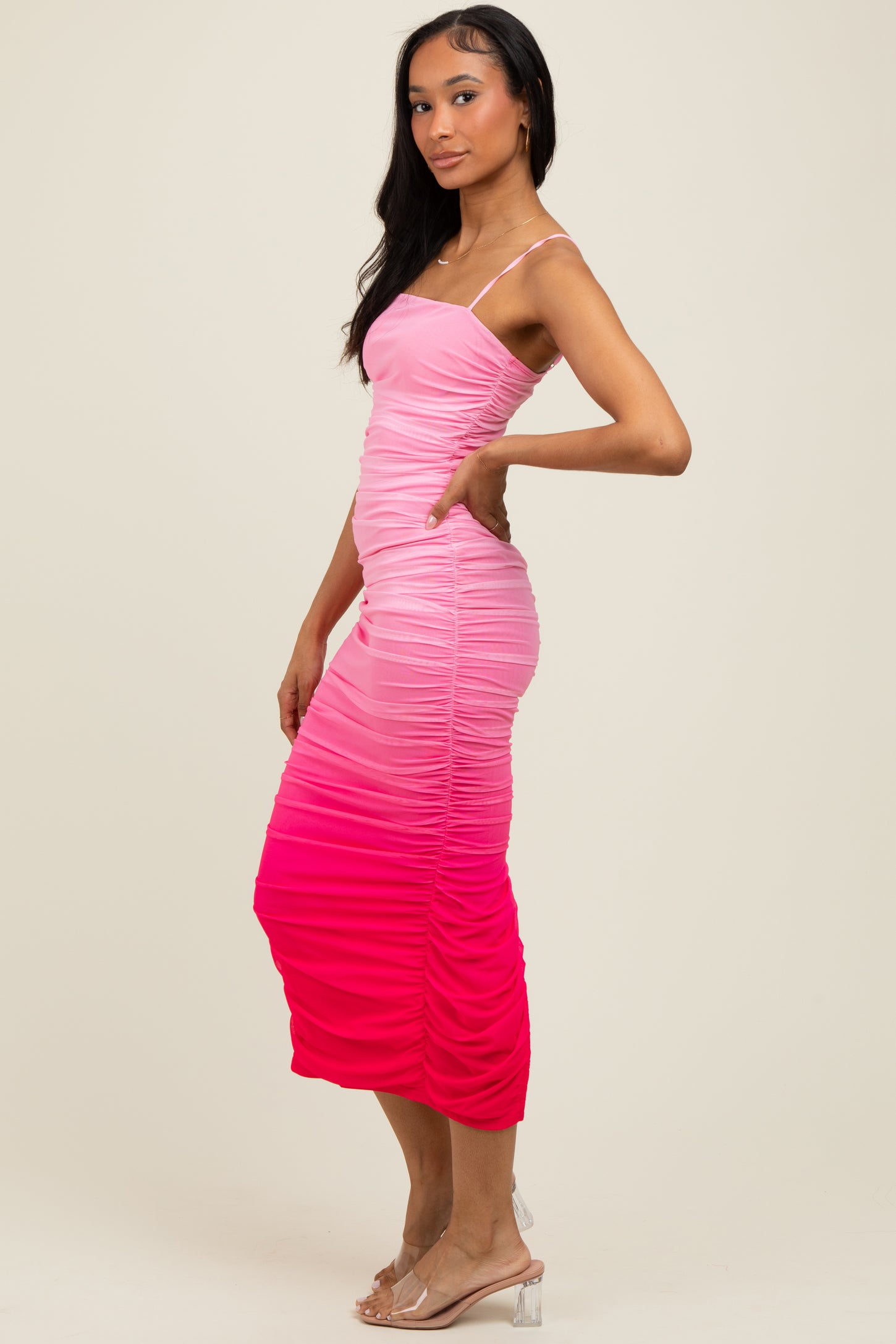 woman wearing a pink ombre midi dress with ruched details and spaghetti straps