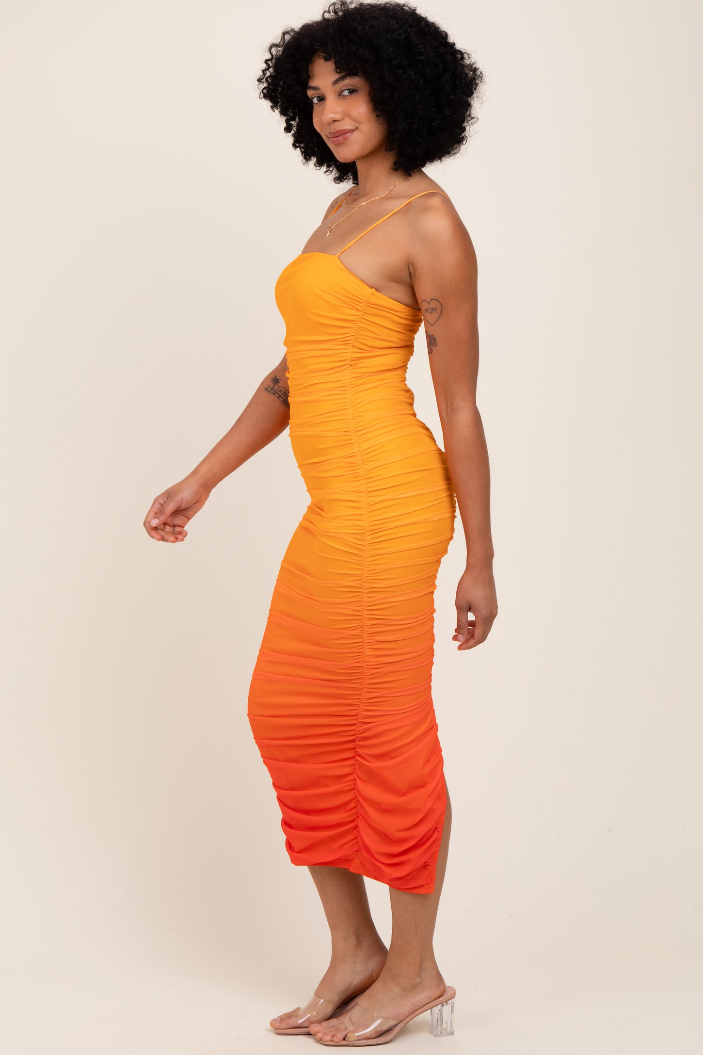 woman wearing a vibrant orange ombre bodycon dress with spaghetti straps and ruched detailing