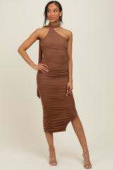 woman wearing a brown one-shoulder ruched midi dress with a side slit and heels