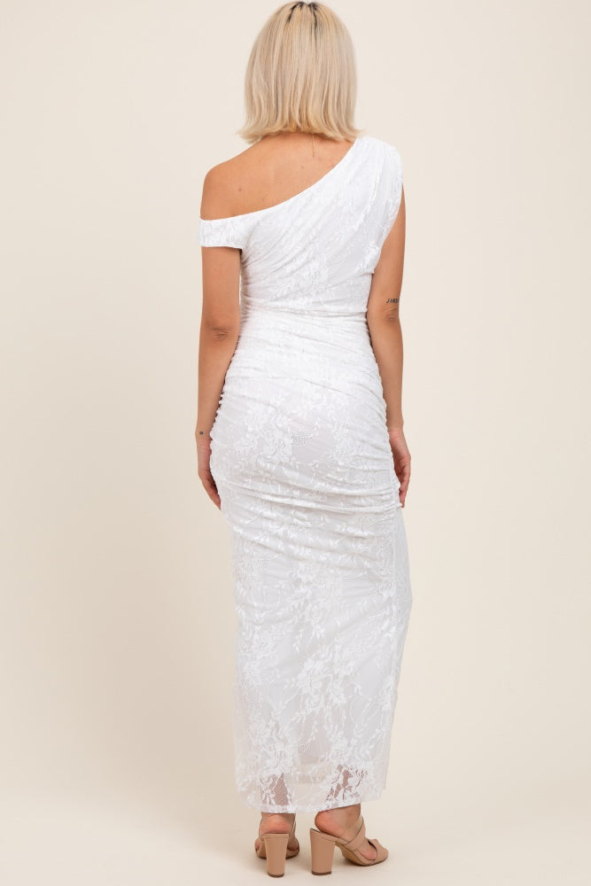 woman wearing a white lace one-shoulder maternity dress with ruching, viewed from the back
