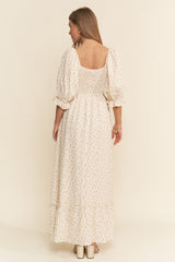 woman wearing a cream floral maxi dress with puff sleeves and a smocked bodice, shown from the back
