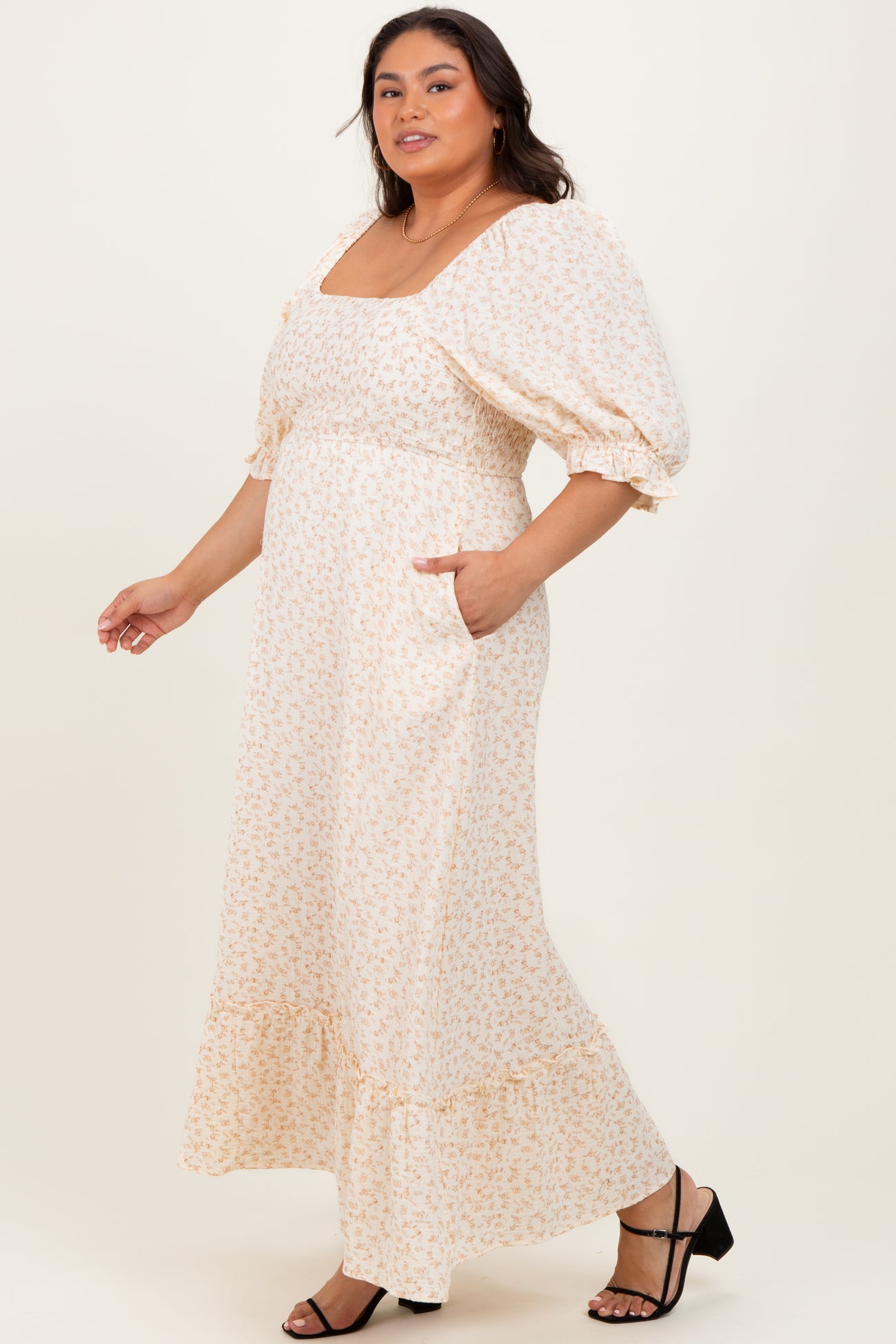 woman wearing a cream floral print maxi dress with puff sleeves and a ruffled hem, featuring pockets and a square neckline