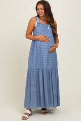woman wearing a light blue striped maternity maxi dress and holding her baby bump