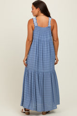 woman wearing a light blue maternity maxi dress with a smocked back and ruffled hem.