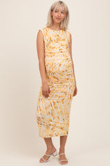 woman wearing a yellow and white patterned maternity midi dress with ruching and a visible baby bump