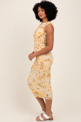 woman wearing a yellow and white tie-dye midi dress with ruching and a fitted silhouette