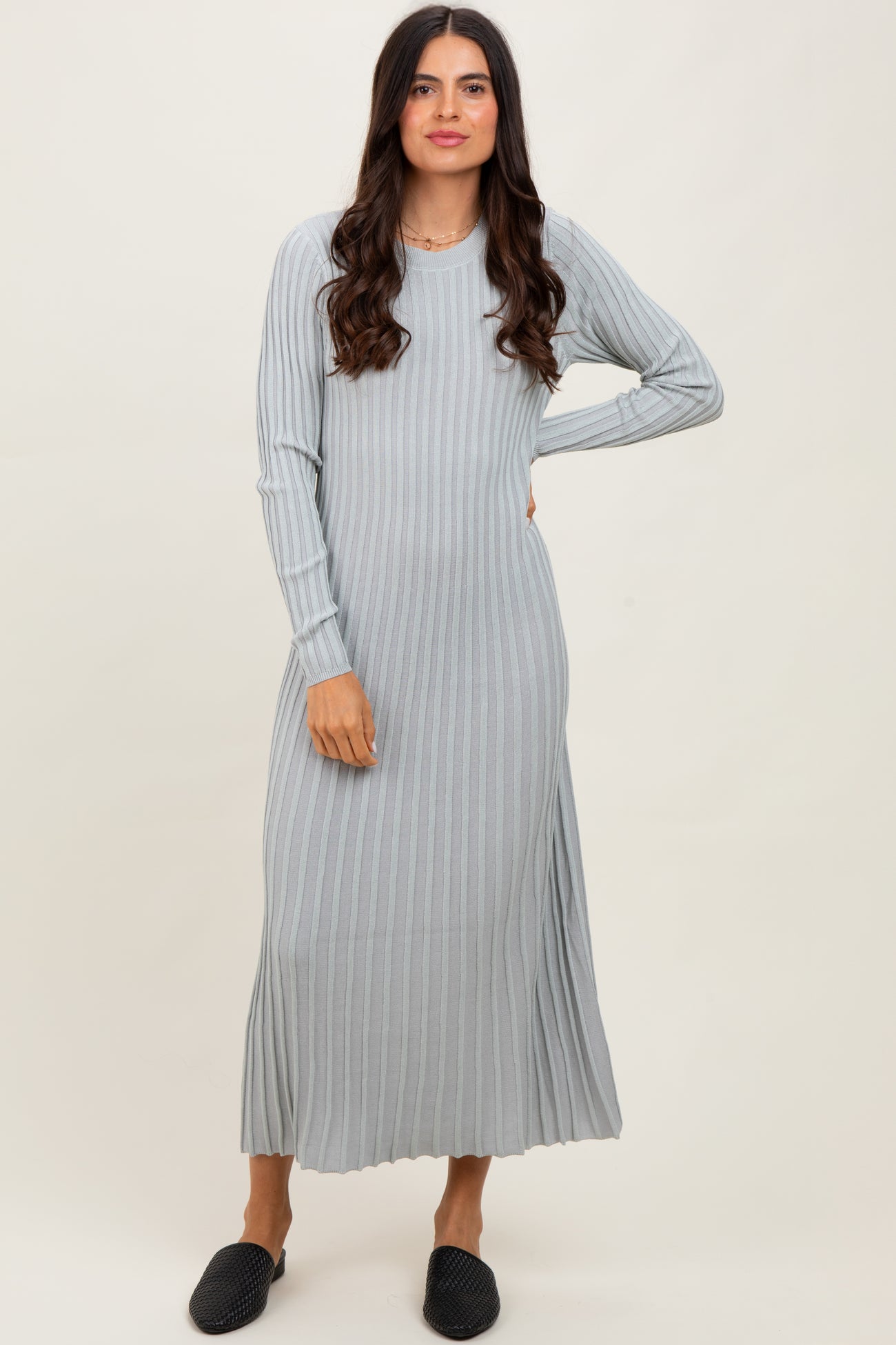 woman wearing a light gray ribbed long sleeve maxi dress and black slip-on shoes