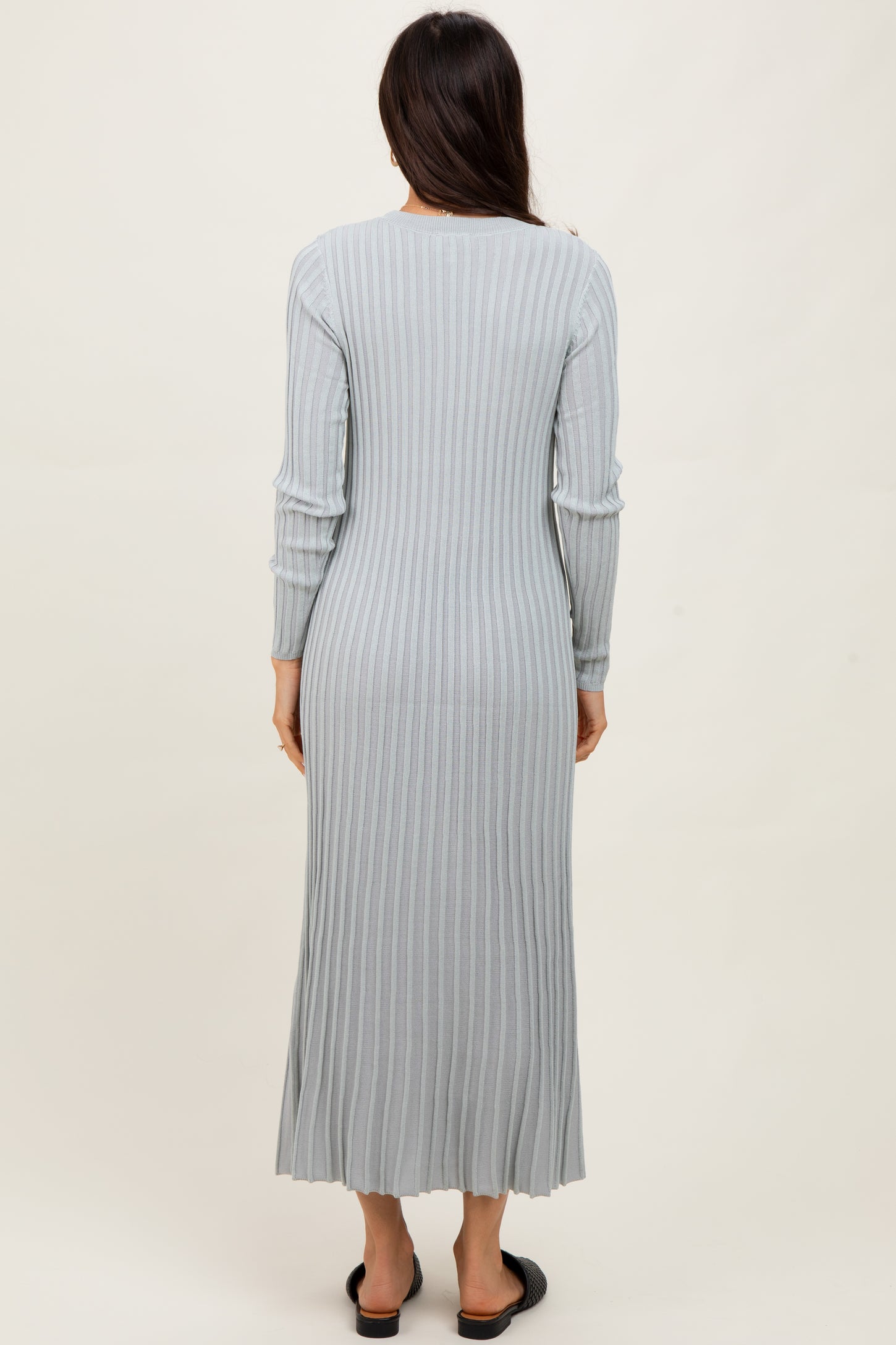 woman wearing a long sleeve light gray ribbed maxi dress viewed from the back