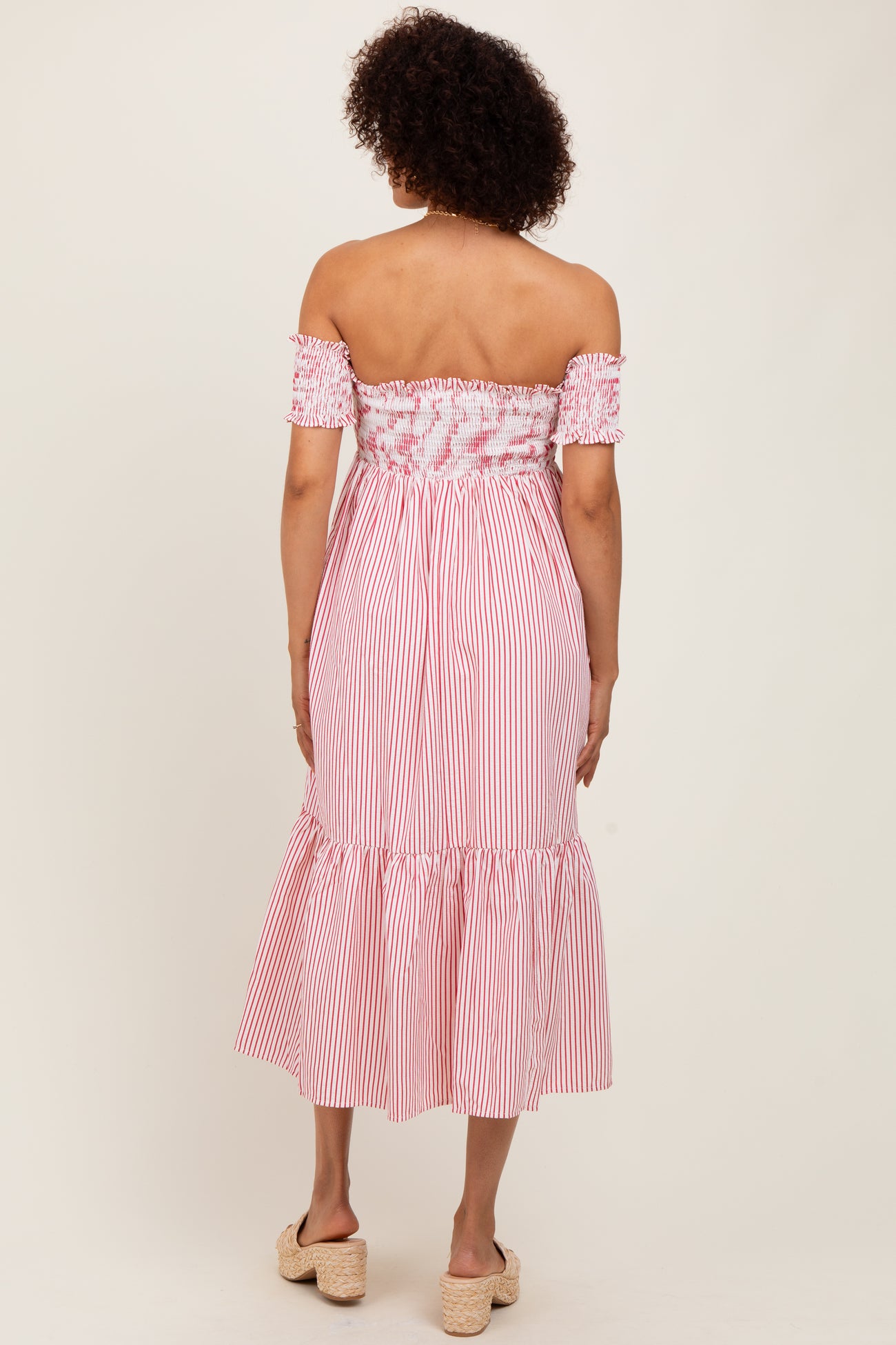 woman wearing a red and white striped off-the-shoulder midi dress with smocked bodice and ruffled hem