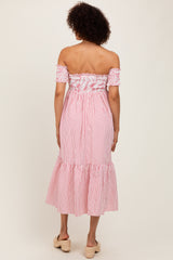 woman wearing a red and white striped off-the-shoulder midi dress with smocked bodice and ruffled hem