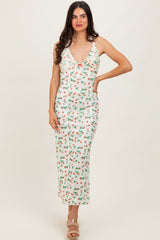 woman wearing a floral print midi dress with a deep v-neckline and ruffled straps, styled with strappy heels