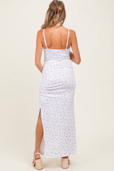 woman wearing a floral maternity maxi dress with a thigh-high slit, showcasing a fitted style and spaghetti straps
