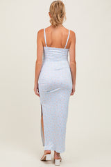 woman wearing a light blue floral maternity maxi dress with a side slit and adjustable straps, showing a baby bump