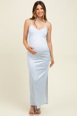 woman wearing a light blue floral maternity maxi dress and holding her baby bump