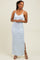 woman wearing a light blue floral print maxi dress with spaghetti straps and side slit