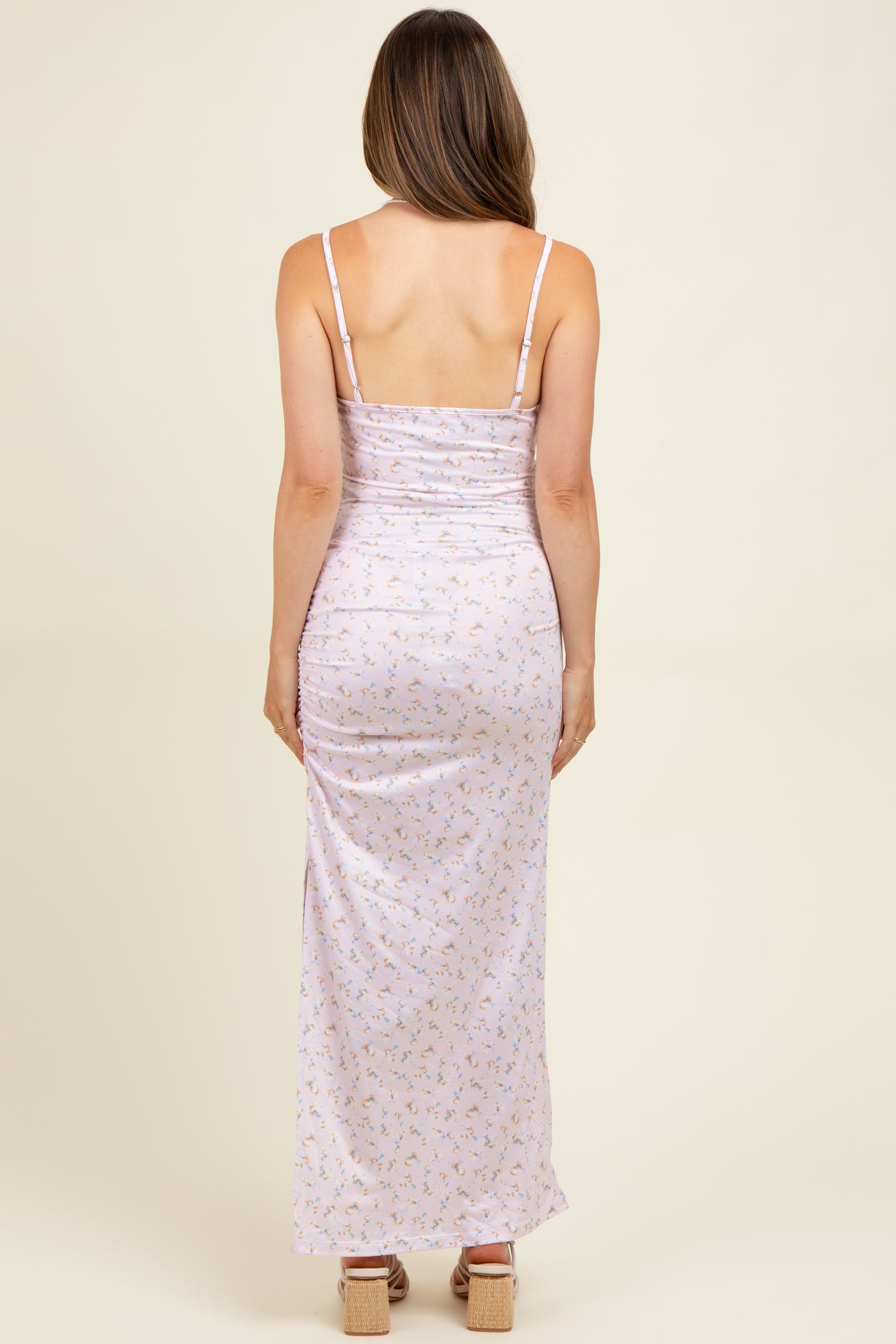 woman wearing a lavender floral maternity maxi dress with adjustable spaghetti straps and a ruched back design
