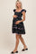 woman wearing a black floral maternity dress with ruffled sleeves and a visible baby bump